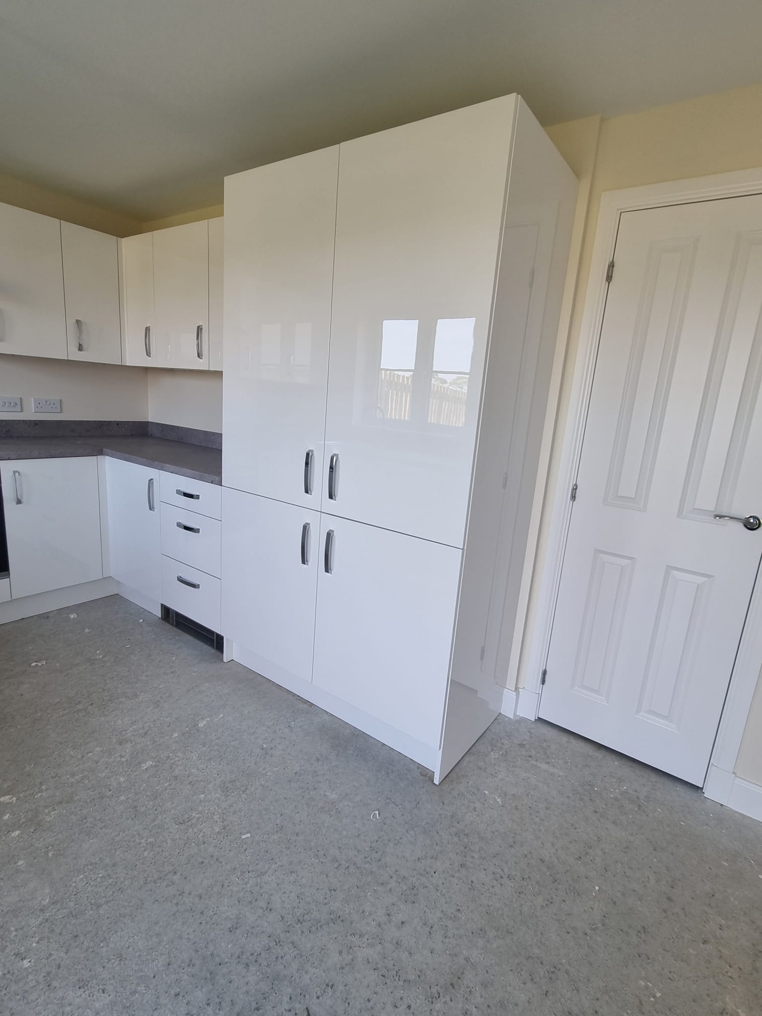 A modern kitchen bathed in natural light from a window on the right wall