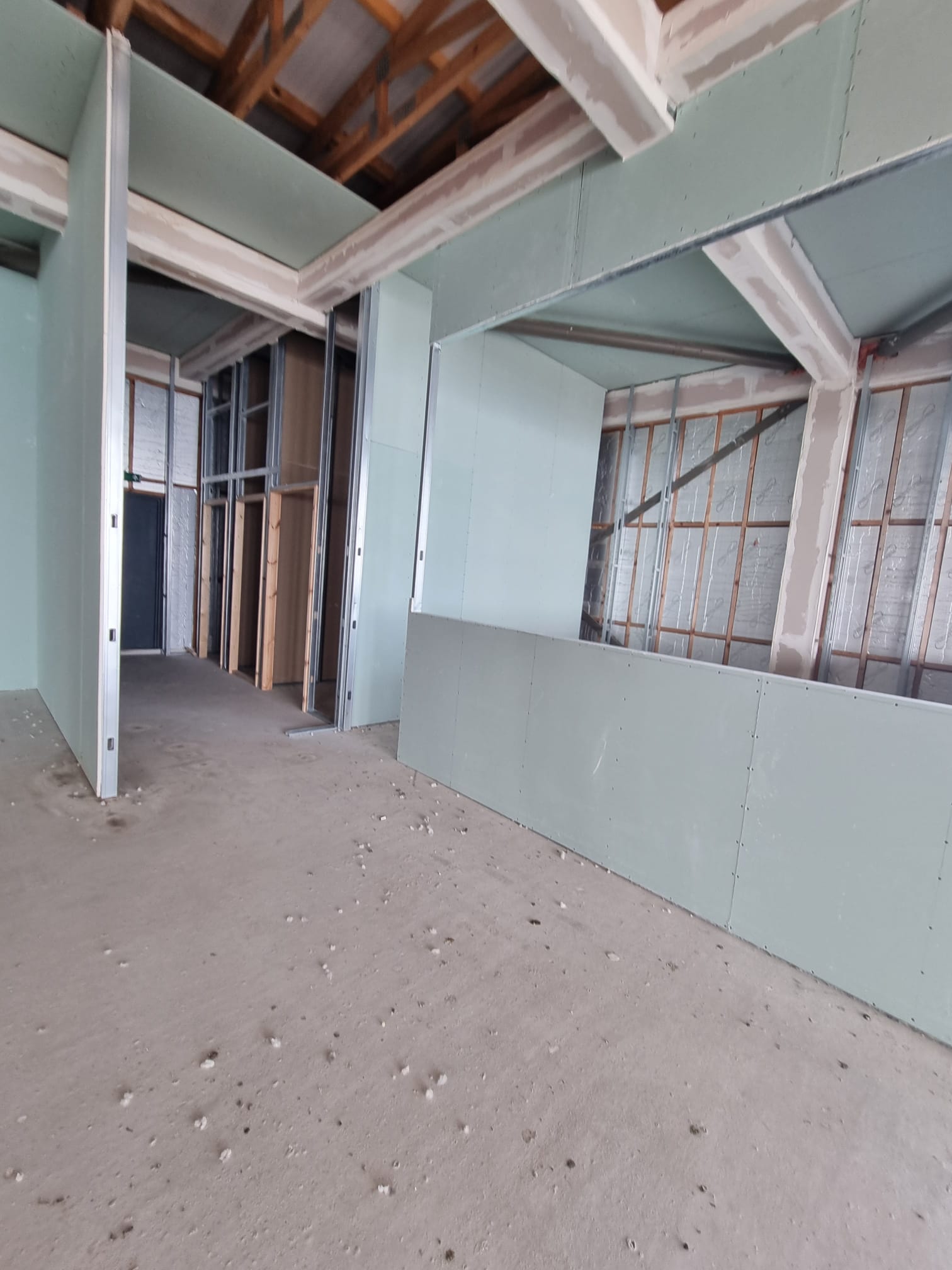 A room that exudes an industrial aesthetic with its concrete floor and walls painted in a soothing shade of light blue