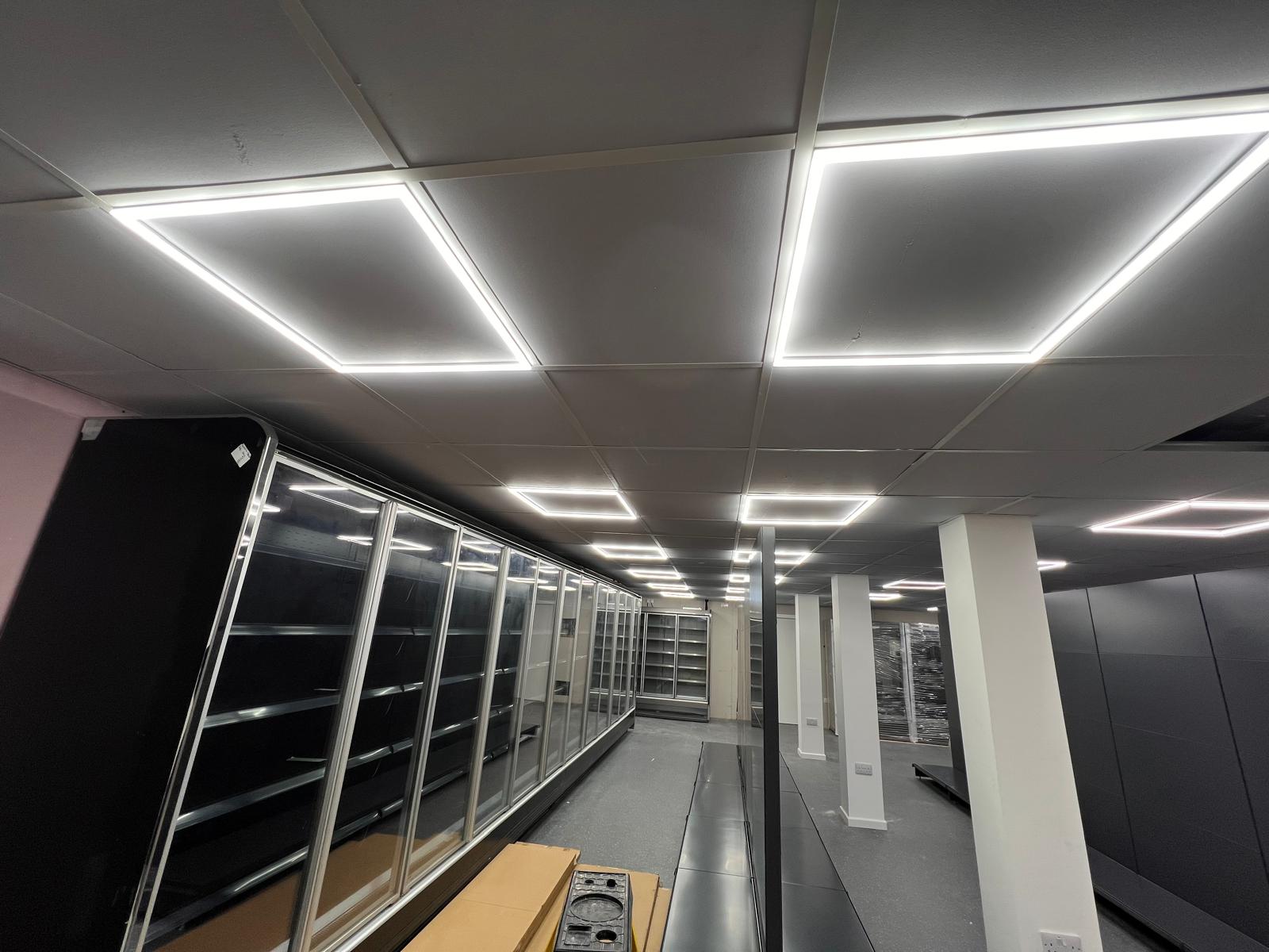 A modern interior space, bathed in the glow of rectangular lights embedded in the ceiling