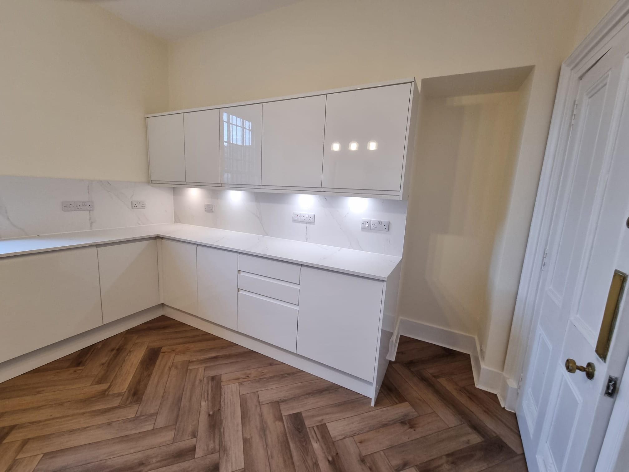 A modern kitchen bathed in natural light from a window on the left wall
